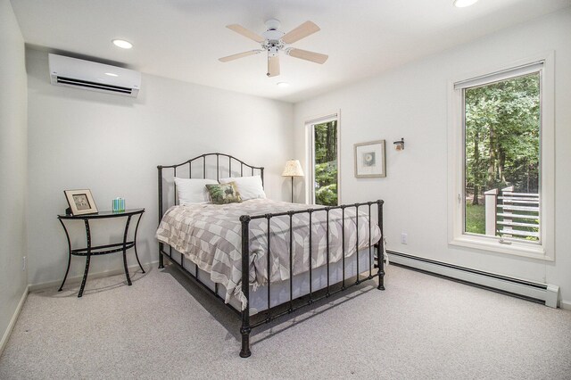 carpeted bedroom with an AC wall unit, ceiling fan, and a baseboard heating unit