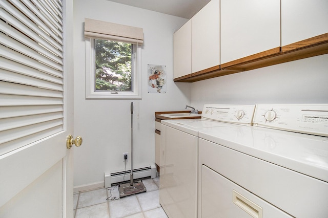 laundry area with washing machine and clothes dryer, a baseboard radiator, light tile patterned flooring, cabinet space, and a sink