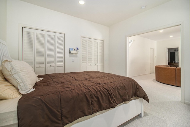 carpeted bedroom featuring recessed lighting and two closets