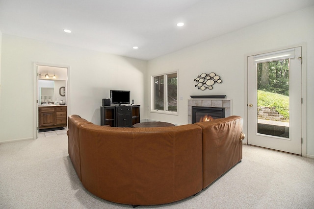 living area featuring recessed lighting, baseboards, light carpet, and a tile fireplace