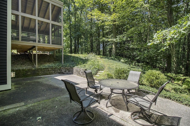 view of patio / terrace with outdoor dining space and a sunroom