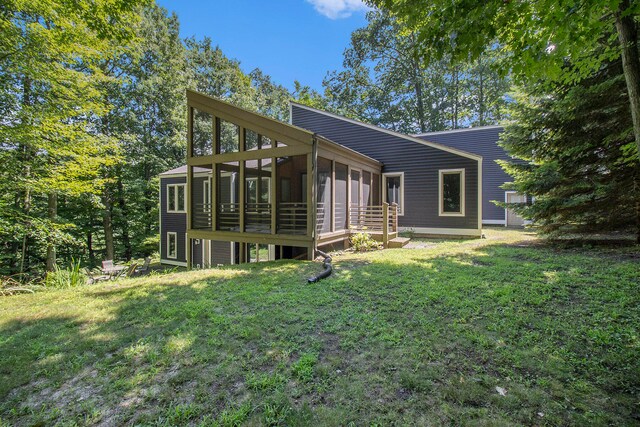 rear view of property with a sunroom and a yard