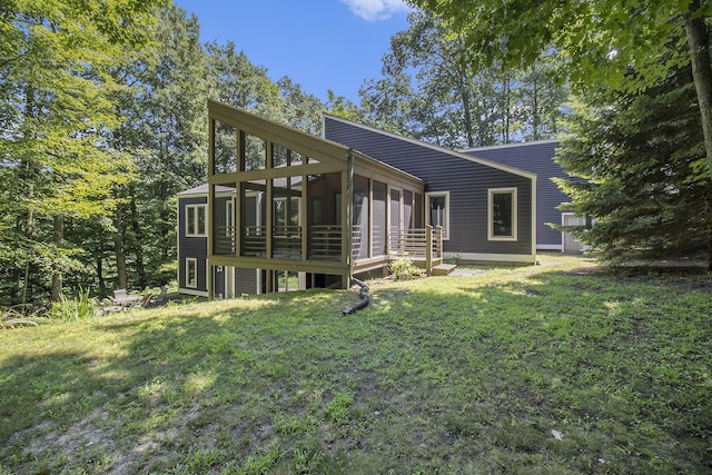 back of house with a lawn and a sunroom