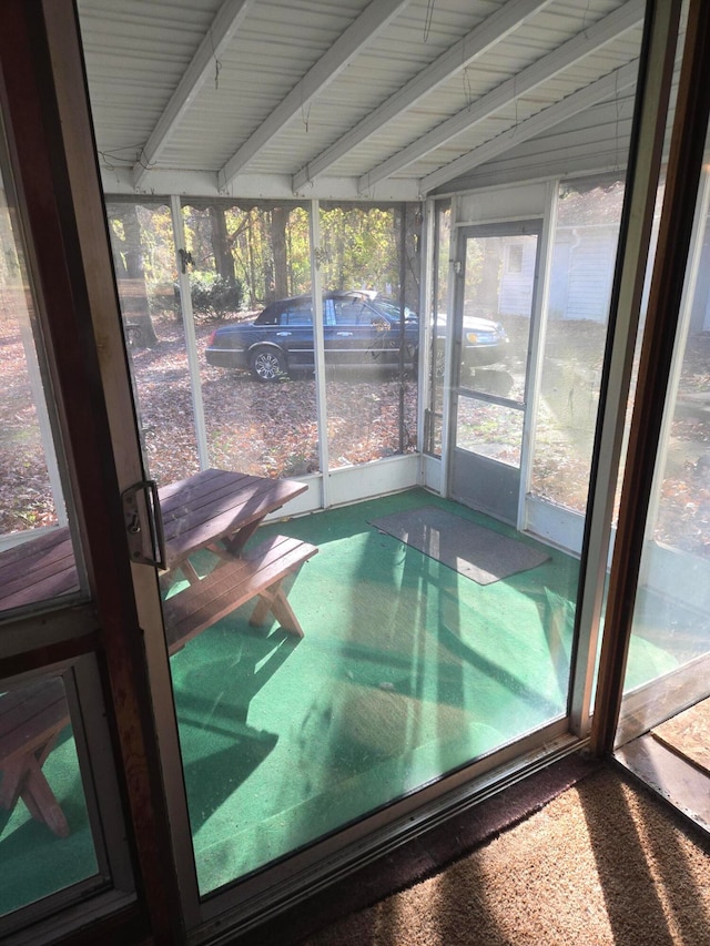 unfurnished sunroom with lofted ceiling with beams