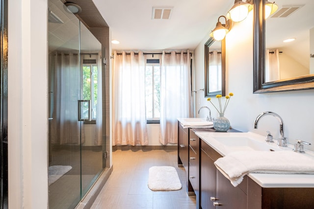 bathroom featuring tile patterned flooring, an enclosed shower, and dual bowl vanity