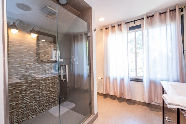 bathroom with tile patterned floors, vanity, and a shower with door