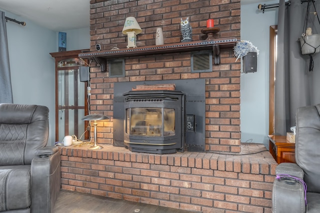 interior details with hardwood / wood-style flooring and a wood stove