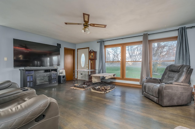 living room with a fireplace, plenty of natural light, dark wood-type flooring, and ceiling fan