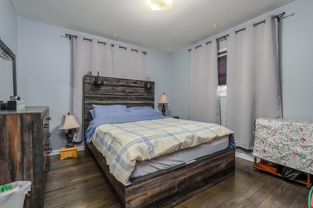 bedroom featuring a textured ceiling and dark wood-type flooring