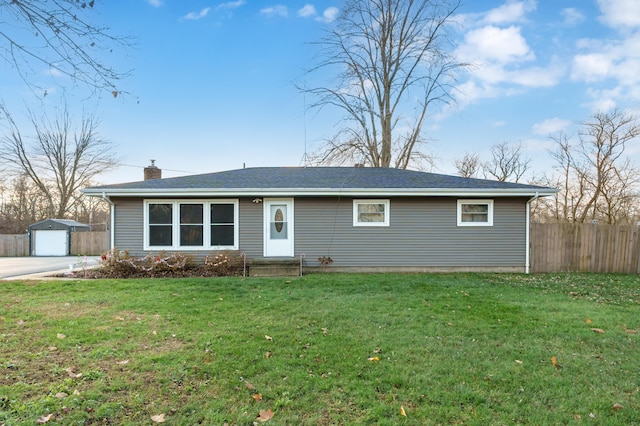 single story home with an outbuilding, a garage, and a front yard