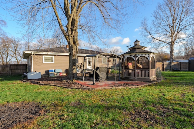 rear view of house with a gazebo, a patio area, and a lawn