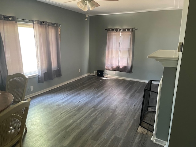 living room featuring dark wood-type flooring, ceiling fan, and ornamental molding