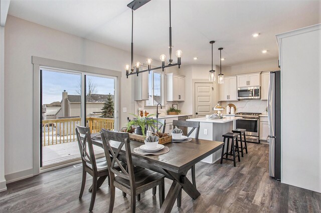 dining space with an inviting chandelier and dark hardwood / wood-style floors