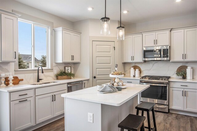 kitchen featuring backsplash, stainless steel appliances, dark hardwood / wood-style flooring, and a center island