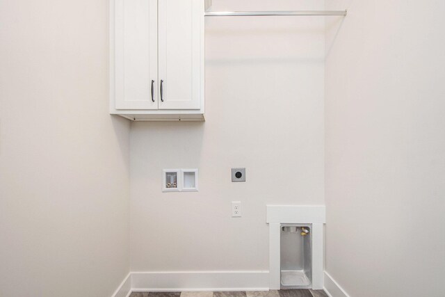 laundry area featuring hardwood / wood-style flooring, electric dryer hookup, cabinets, and washer hookup