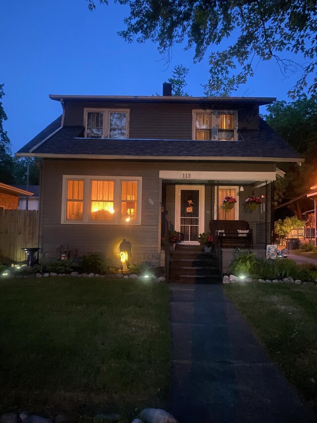 view of front of home featuring covered porch and a front lawn