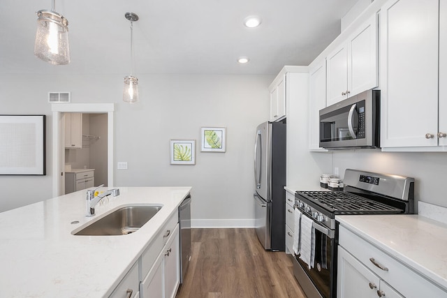 kitchen featuring sink, appliances with stainless steel finishes, hanging light fixtures, and dark hardwood / wood-style floors