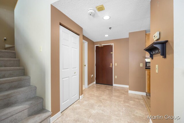 interior space with a textured ceiling and light tile patterned floors