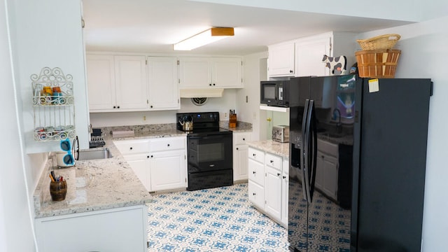 kitchen with white cabinets, black appliances, light stone counters, and sink