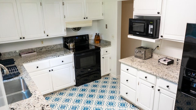 kitchen with light tile patterned flooring, white cabinets, black appliances, and custom range hood