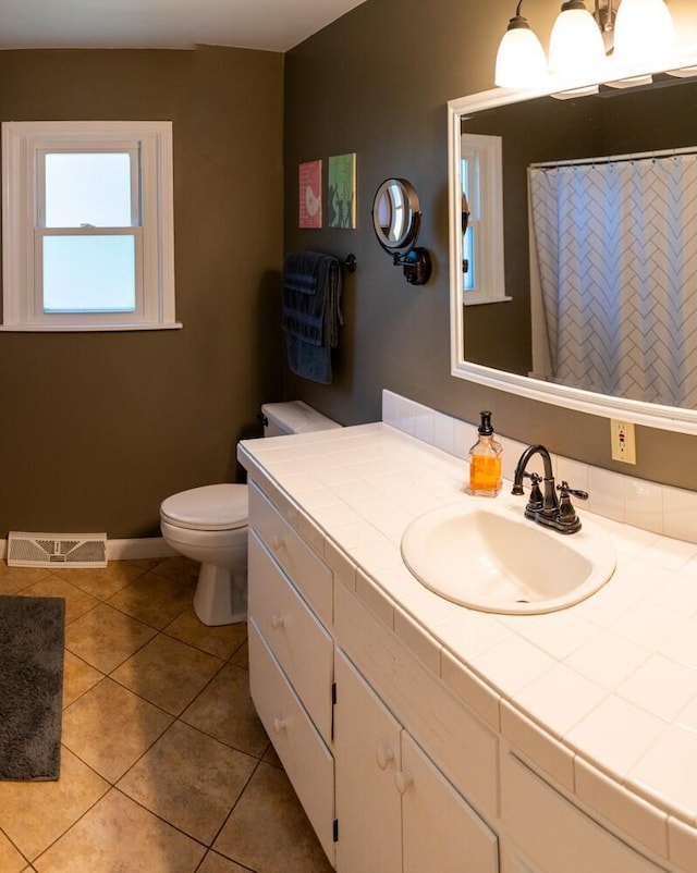 bathroom with vanity, tile patterned flooring, and toilet