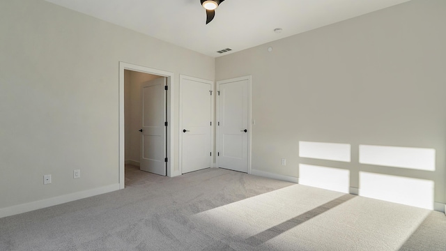 bedroom with visible vents, light colored carpet, a ceiling fan, and baseboards