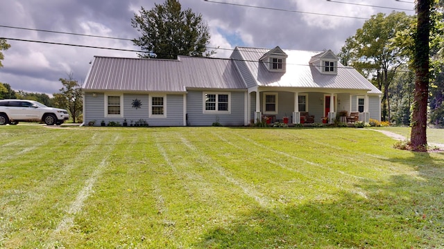 cape cod home with metal roof, a porch, and a front yard