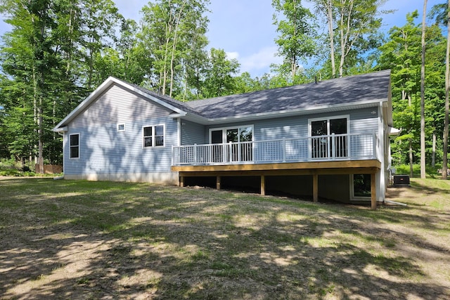 rear view of house featuring a deck and a lawn