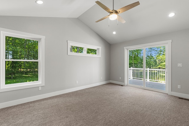 unfurnished room featuring vaulted ceiling, carpet flooring, a wealth of natural light, and ceiling fan