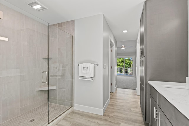 bathroom with wood-type flooring, vanity, and walk in shower