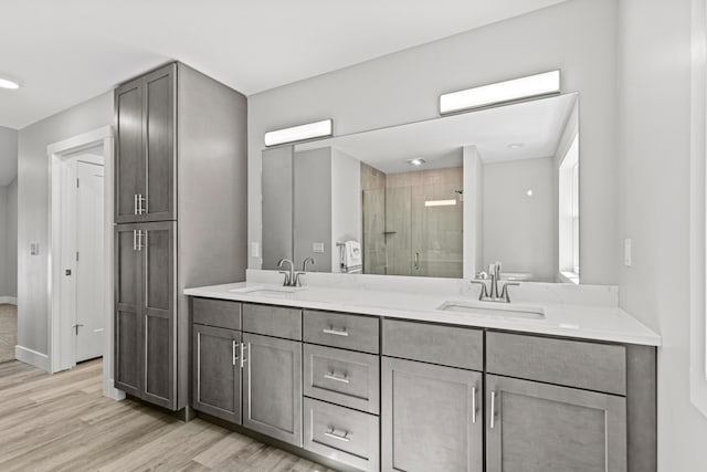 bathroom featuring vanity, hardwood / wood-style floors, and a shower with shower door