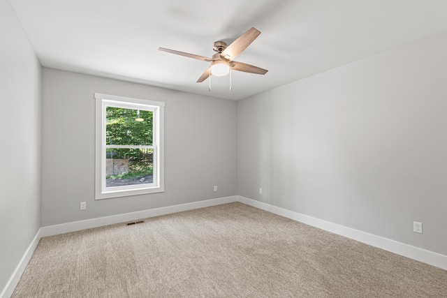 carpeted spare room with ceiling fan