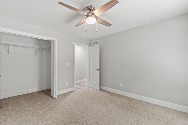 unfurnished bedroom with ceiling fan, a closet, and light carpet