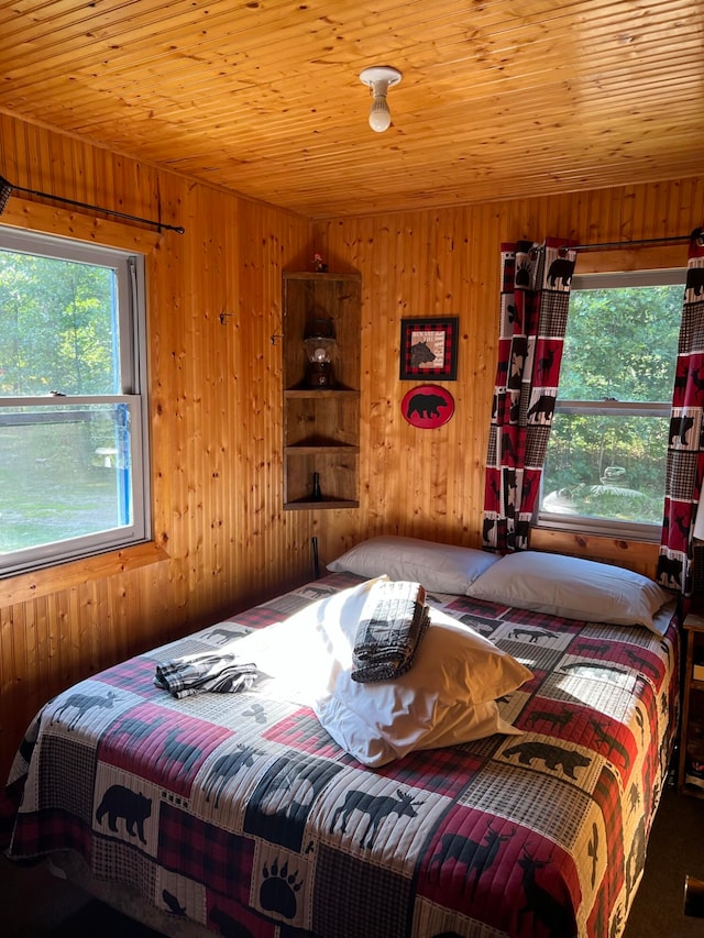 bedroom featuring wooden ceiling and wooden walls