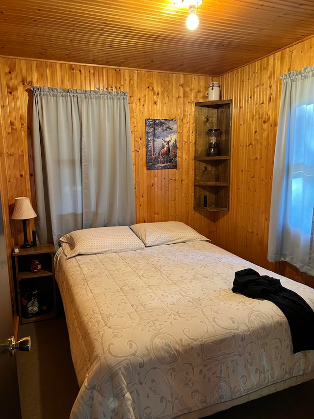 bedroom with wood walls and wooden ceiling