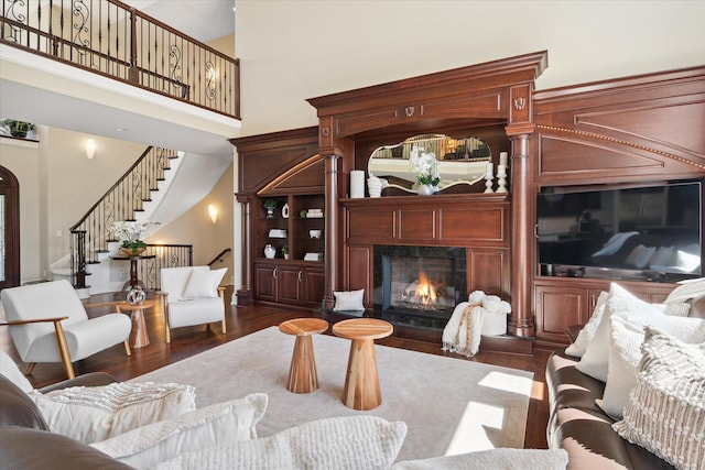 living room with dark wood-type flooring and a towering ceiling