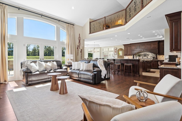 living room with dark hardwood / wood-style floors, a chandelier, and a healthy amount of sunlight