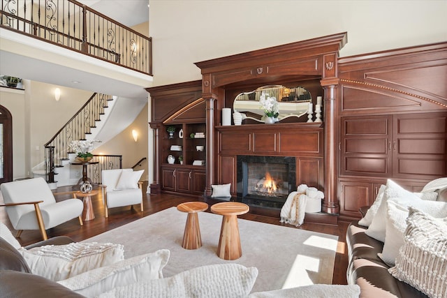 living room with dark hardwood / wood-style floors and a towering ceiling