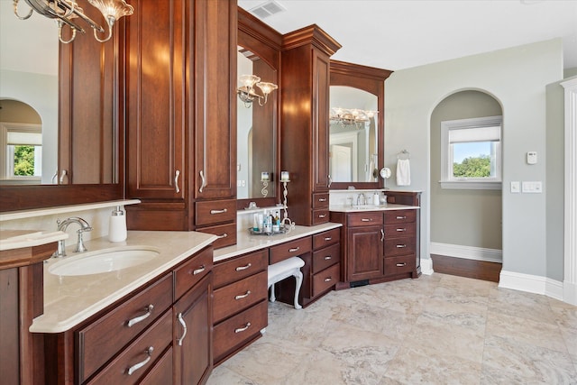 bathroom with plenty of natural light, vanity, and a notable chandelier