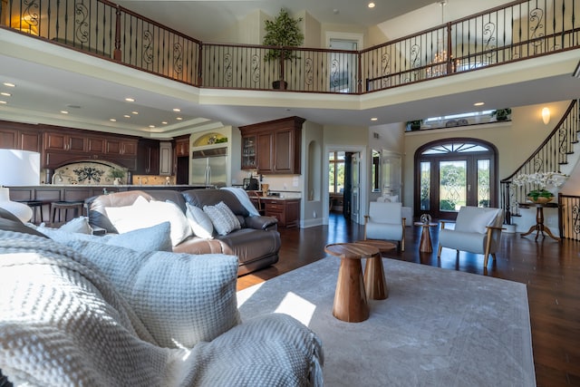 living room featuring dark wood-type flooring and a high ceiling