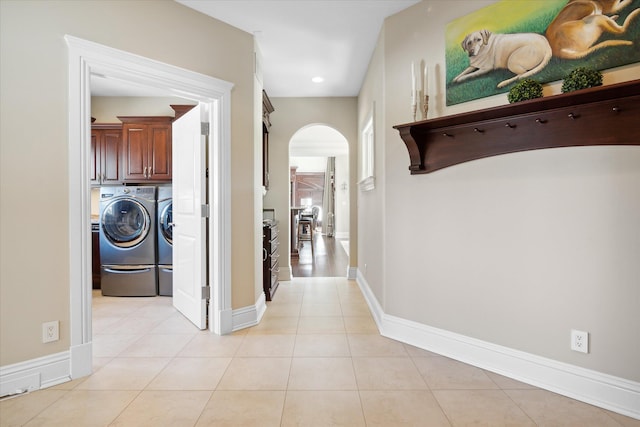 hall with washer and dryer and light tile patterned flooring