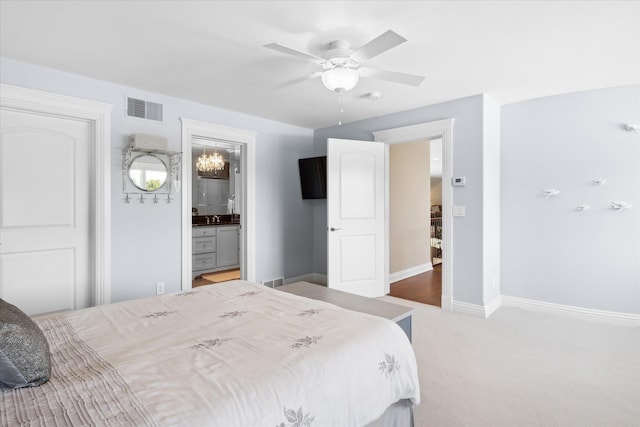 carpeted bedroom featuring ceiling fan and ensuite bath