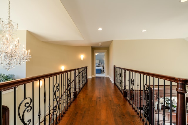 hall featuring dark wood-type flooring and an inviting chandelier