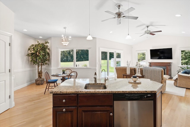 kitchen with light hardwood / wood-style floors, sink, stainless steel dishwasher, and an island with sink