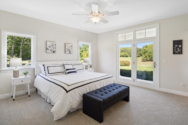 bedroom with ceiling fan, access to exterior, light colored carpet, and multiple windows