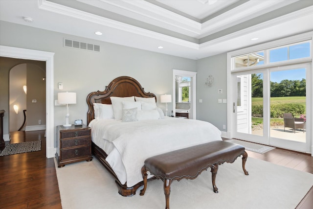 bedroom featuring hardwood / wood-style floors, crown molding, a raised ceiling, and access to outside