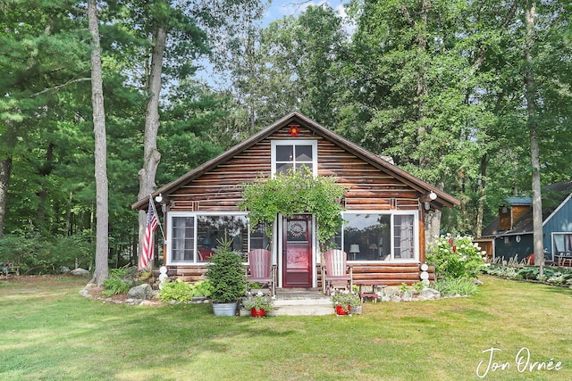 log-style house with a sunroom and a front lawn