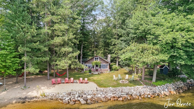 exterior space with a fire pit, an outdoor structure, and a water view