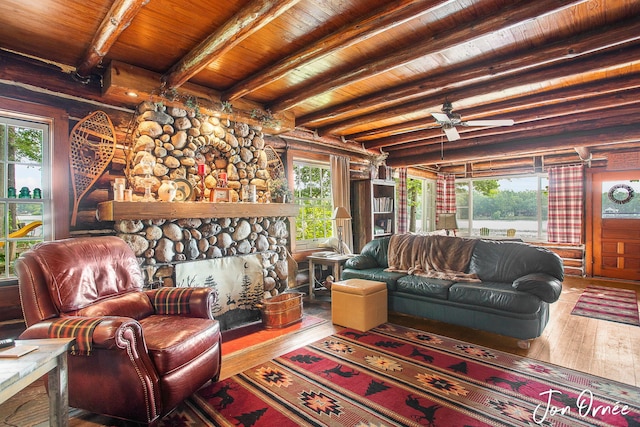 living room with wood ceiling, hardwood / wood-style flooring, ceiling fan, a fireplace, and beamed ceiling