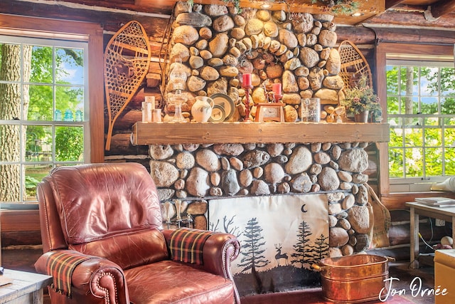 living area featuring log walls and a fireplace